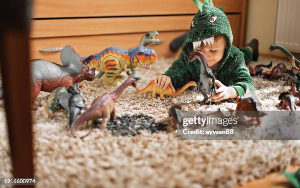 adorable boy playing with his dinosaurs - children playing with toys imagens e fotografias de stock