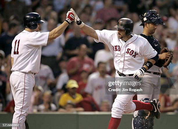 Boston Red Sox's Kevin Millar, center, is congratulated by teammate Bill Mueller, right, after Millar hit the third of three home runs against the...