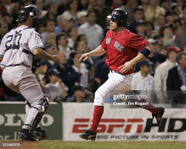 Boston Red Sox Mark Bellhorn scores while New York Yankees catcher Jorge Posada awaits the throw at Fenway Park in Boston, Sunday, July 25, 2004. The...