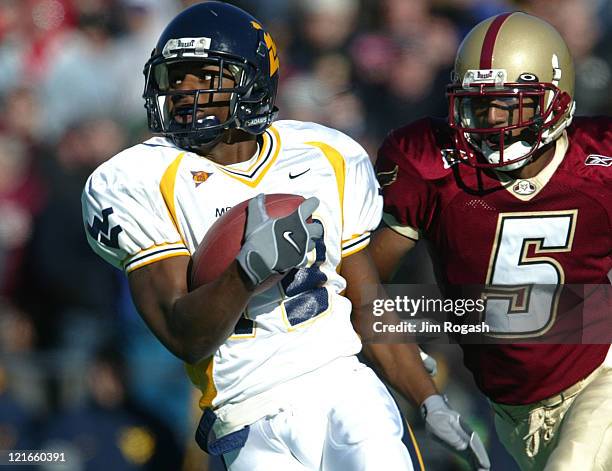 West Virginia's defensive back Lance Frazier, left, snags a pass intended for Boston College wide receiver Grant Adams, right, for an interception...