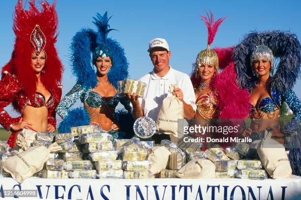 Jim Furyk of the United States celebrates with the trophy, $450,000 and showgirl performers after winning the PGA Las Vegas Invitational golf...
