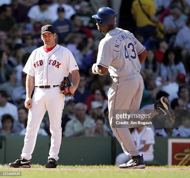 Boston Red Sox third baseman Kevin Youkilis,left, can only watch as Los Angeles Dodgers' Juan Encarnacion rounds the bases after hitting a home run...