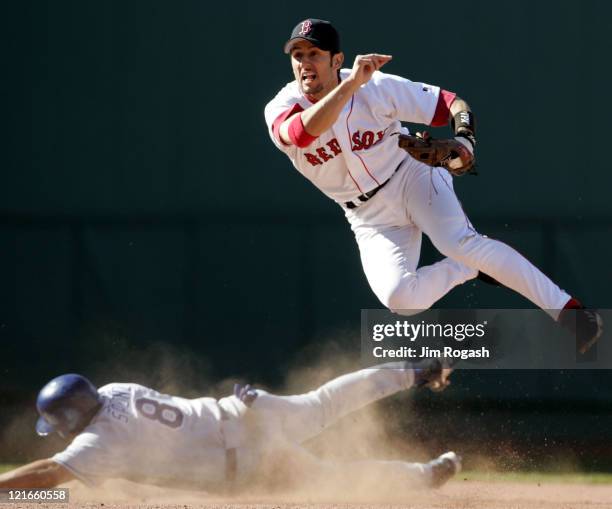 Boston Red Sox Nomar Garciaparra, right, turn a double play as Los Angeles Dodgers' base runner Olmedo Saenz slides into second at Fenway Park in...