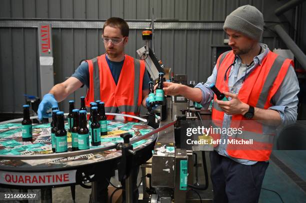 Martin Dickie and James Watt from BrewDog brewery pack hand sanitizer being produced at the plant on April 03, 2020 in Ellon, Scotland. Scotland...