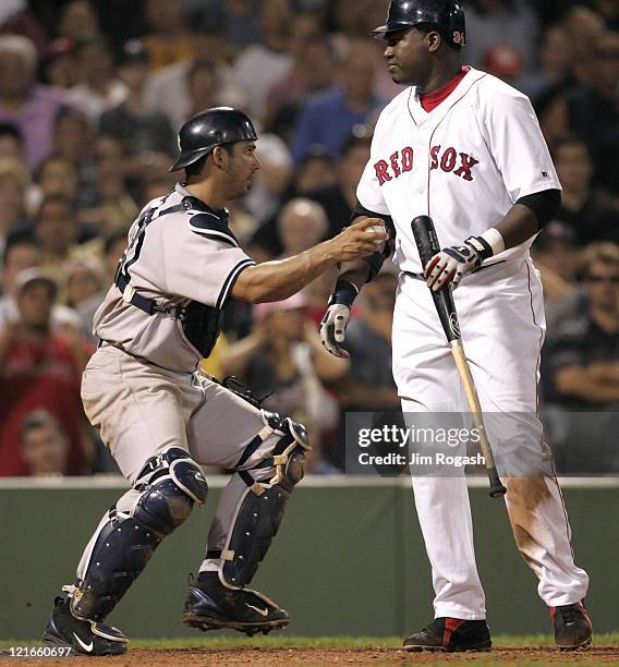 Boston Red Sox batter David Ortiz, right, is tagged out by New York Yankees catcher Jorge Posada after Ortiz struck out swinging at Fenway Park in...