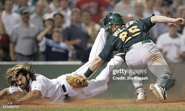 Boston Red Sox base runner Johnny Damon, left, avoids the tag Oakland Athletics catcher Damian Miller to score the winning run at Fenway Park in...