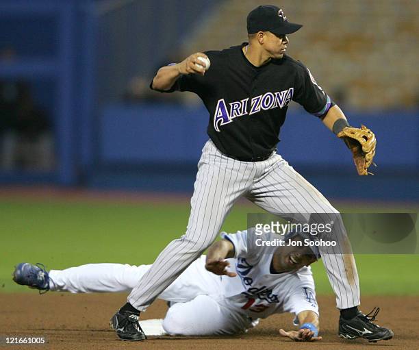Arizona Diamondbacks Alex Cintron turns a double play aftergetting Alex Cora of the Los Angeles Dodgers out at second base during the 1-4 loss to the...