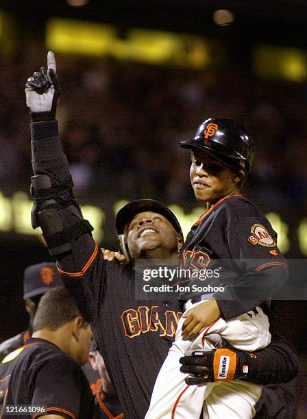 Barry Bonds is greeted at Home Plate by his son after hitting his 72nd home run of the season to Break Mark McGwire's single season record.