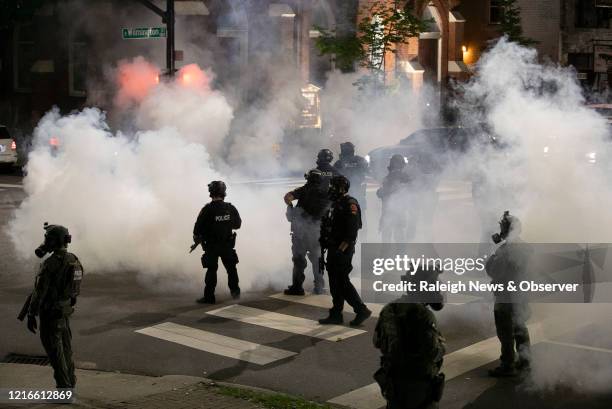 Raleigh police fire tear gas to disperse a crowd of demonstrators in front of the First Baptist Church at the corner of South Wilmington and East...