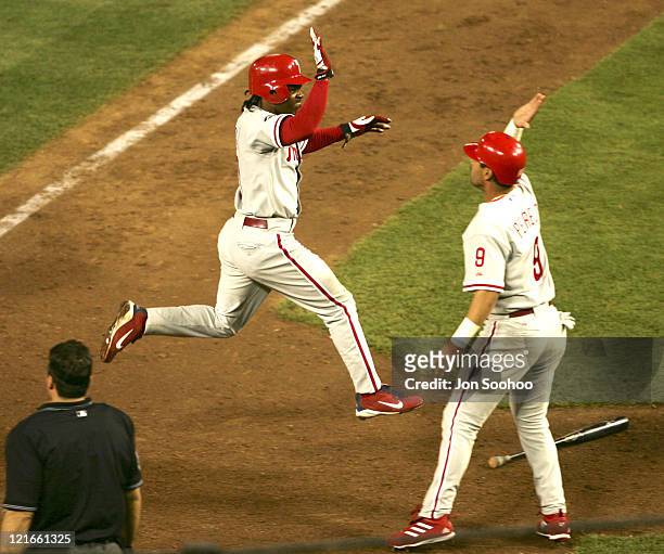Philadelphia Phillies Jimmy Rollins high fives teammate Tomas Perez after scoring go ahead run a vs Los Angeles Dodgers Eric Gagne at Dodger Stadium