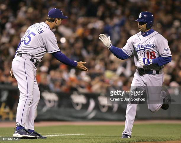 Los Angeles Dodgers Jose Hernandez is greeted by third base coach Glenn Hoffman after homering vs San Francisco Giants, September 24, 2004 at SBC...