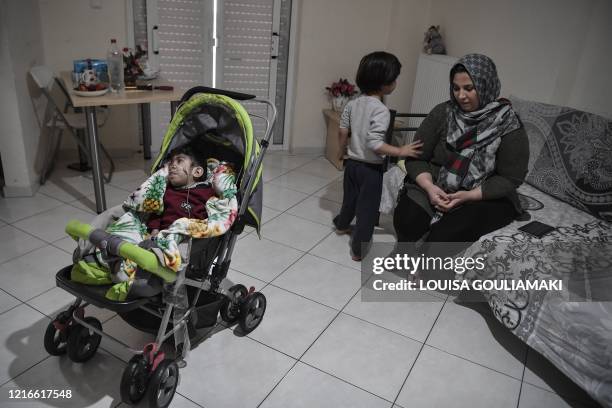 Asil Nadawi, an Iraqi recognised refugee, sits with one of her twins, at her family apartment in the working class district of Piraeus near Athens,...