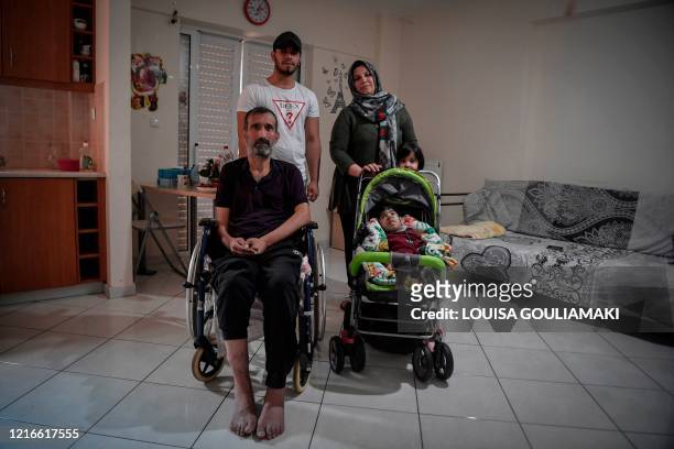 Asil Nadawi, an Iraqi recognised refugee poses with her disabled husband, and three of her five children at her family apartment in the working class...