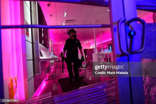 Police investigate a looted T-Mobile store during widespread unrest following the death of George Floyd on May 31, 2020 in Philadelphia,...