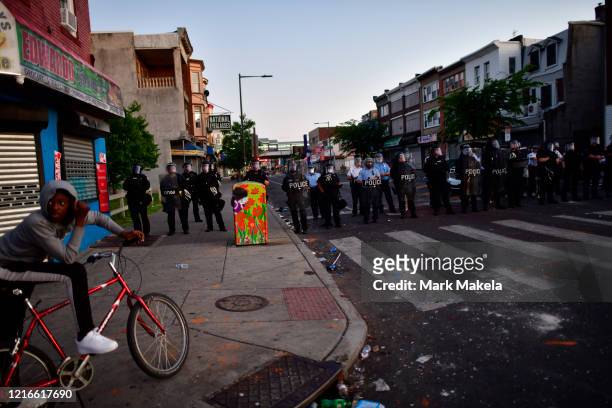 Police create a barrier in front of a damaged police vehicle during widespread unrest following the death of George Floyd on May 31, 2020 in...