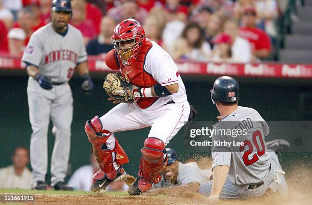 Lew Ford of the Minnesota Twins slides safely into home plate to beat tag of Los Angeles Angels of Anaheim catcher Bengie Molina as Minnesota...