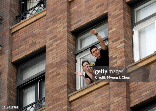 Residents cheer from above as protesters take to the streets in downtown Los Angeles on Sunday, May 31, 2020 in Los Angeles, CA.