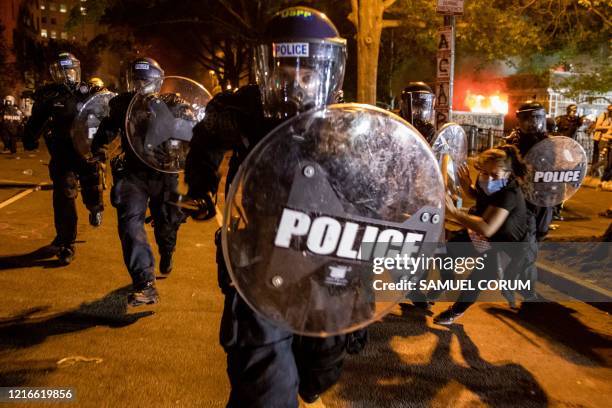 Police officer charges forward as people protest the death of George Floyd at the hands of Minneapolis Police in front of the White House in...