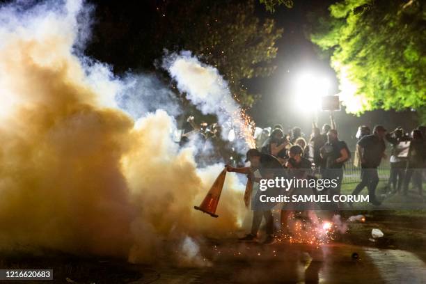 Protestor tries to put a traffic cone over a tear gas canister during a face off with police in front of the White House protesting the death of...