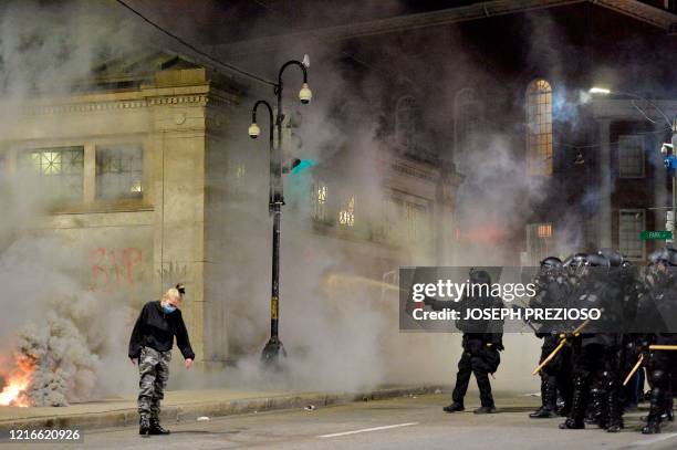 Police shoot pepper spray toward a protester during a demonstration over the death of George Floyd, an unarmed black man who died in Minneapolis...