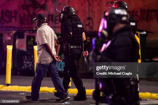 Police officers arrest a man during the fourth consecutive day of protests on May 31, 2020 in Denver, Colorado. The city of Denver enacted a curfew...