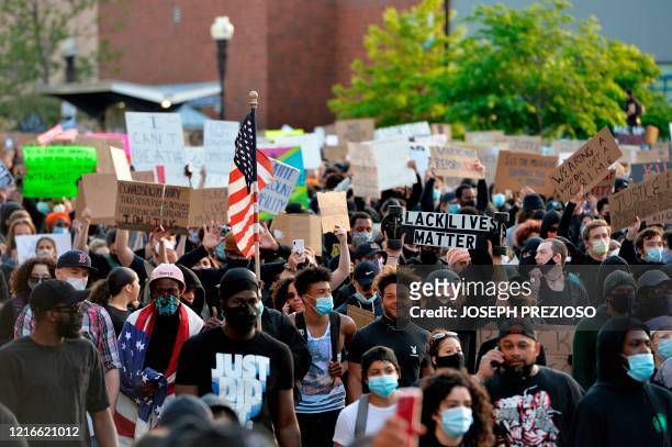 Protesters hold up signs as they march during a demonstration over the death of George Floyd, an unarmed black man who died in Minneapolis Police...