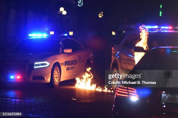 Ferguson police officer reacts as a flammable object is thrown a a police cruiser following a protest at the Ferguson Police Department on May 31,...