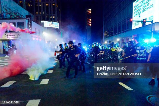 Smoke rises around police as they spray pepper spray during clashes with protesters after a demonstration over the death of George Floyd, an unarmed...