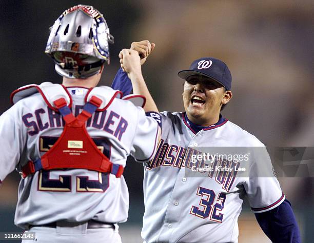 Washington pitcher Chad Cordero is congratulated by catcher Brian Schneider after striking out Los Angeles third baseman Dallas McPherson for the...