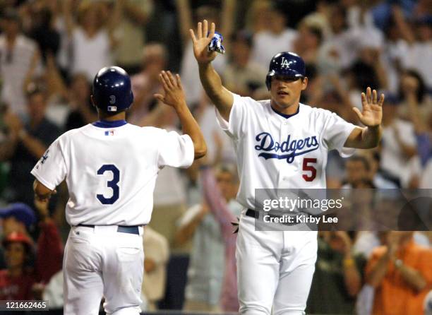 Cesar Izturis of the Los Angeles Dodgers is congratulated by Hee-Seop Choi after scoring in they scored on a single by Milton Bradley in the seventh...