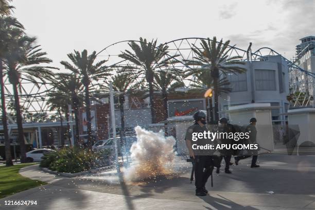 Fireworks hurled by demonstrators explode next to police officers in downtown Long Beach on May 31, 2020 during a protest against the death of George...