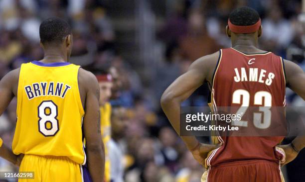 Kobe Bryant of the Los Angeles Lakers and LeBron James of the Cleveland Cavaliers stand next to each other during the game between the Cleveland...