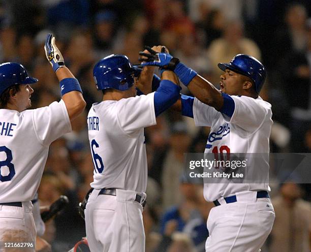 Wilson Betemit , right, of the Los Angeles Dodgers exchanges high-fives with Andy LaRoche and Andre Etheir after hitting a three-run pinch hit home...