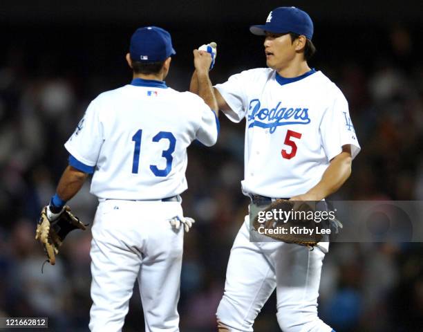 Hee-Seop Choi and Oscar Robles of the Los Angeles Dodgers celebrate the final out of 5-4 victory over the San Diego Padres at Dodger Stadium in Los...