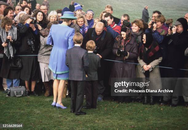 British royals Diana, Princess of Wales , wearing a blue and turquoise suit by Catherine Walker, with a matching hat, Prince William and Prince Harry...