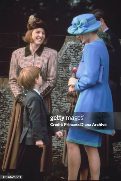 British royals Sarah, Duchess of York, Prince Harry, and Diana, Princess of Wales , wearing a blue and turquoise suit by Catherine Walker, with a...