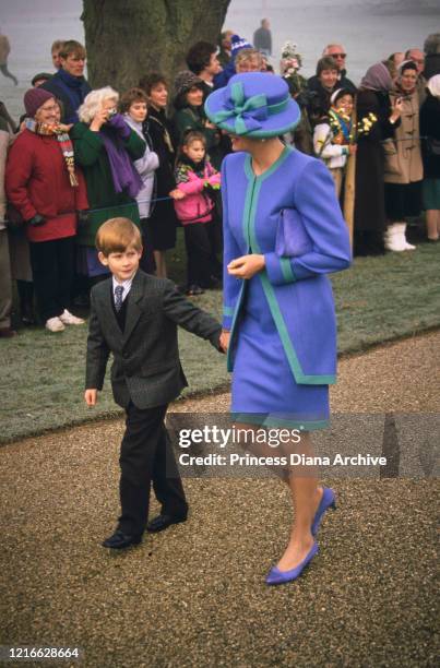 British royals Prince Harry and his mother Diana, Princess of Wales , wearing a blue and turquoise suit by Catherine Walker, with a matching hat,...