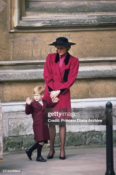 British royal Diana, Princess of Wales , wearing a red coat with black lapels and a black hat, and Prince Harry attend the Easter service at St...