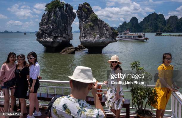 Vietnamese tourists pose for photographs on a boat touring Ha Long Bay, after the Vietnamese government eased the lockdown following the coronavirus...