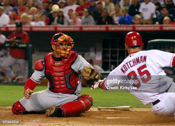 Casey Kotchman of the Los Angeles Angels of Anaheim slides safety into home plate after a bobbled throw to Boston Red Sox catcher Jason Varitek in...