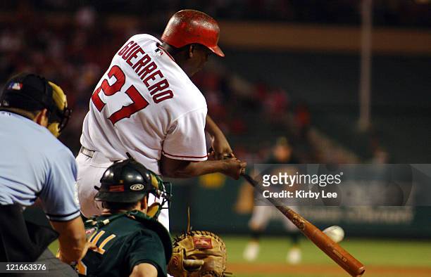 Vladimir Guerrero of the Los Angeles Angels of Anaheim bats as Oakland Athletics catcher Jason Kendall and home plate umpire Chris Guccione watch....