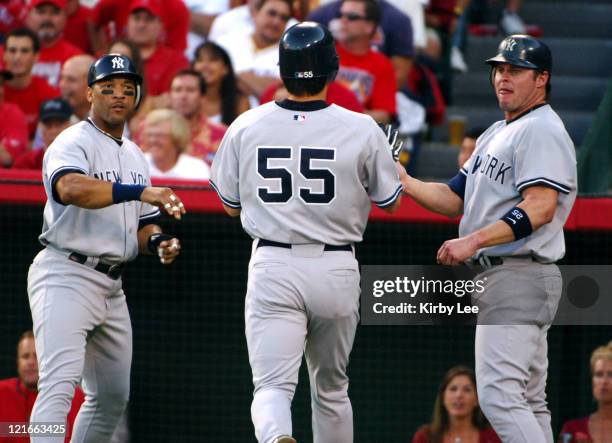 Hideki Matsui of the New York Yankees is greeted by Gary Sheffield and Jason Giambi after scoring in the first inning of 4-2 victory over the Los...
