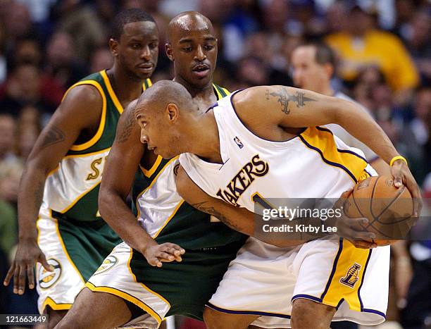 Caron Butler of the Los Angeles Lakers is defended by Damien Wilkins of the Seattle SuperSoncis during the game between the Seattle SuperSonics and...