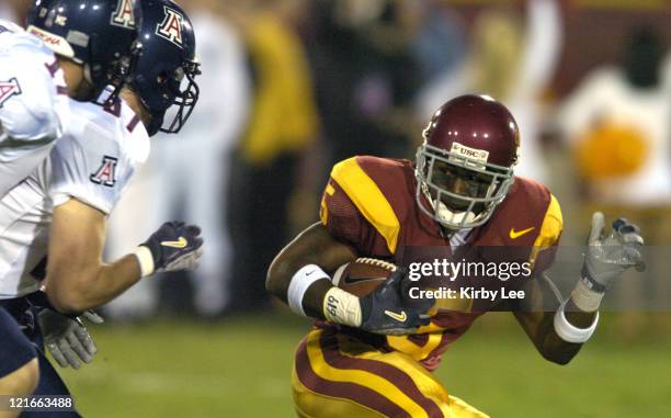 Reggie Bush of USC is pursued by Arizona defenders on a punt return during 49-9 victory in Pacific-10 Conference football game at the Los Angeles...