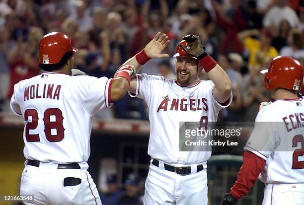 Jose Molina of the Anaheim Angels is greeted by Josh Paul and David Eckstein after hitting a seventh-inning grand slam in 21-6 victory over the...
