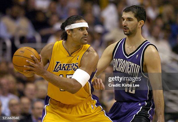 Rick Fox of the Los Angeles Lakers is guarded by Peja Stojakovic of the Sacramento Kings during the game between the Sacramento Kings and the Los...