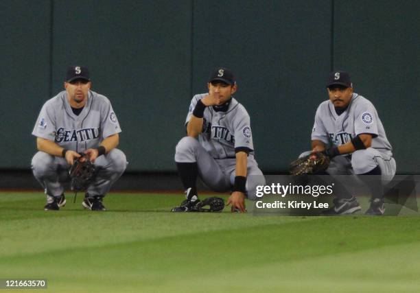 Seattle Mariners outfielders Raul Ibanez, Ichiro Suzuki and Jason Ellison huddle during a pitching change in a 12-5 victory over the Los Angeles...