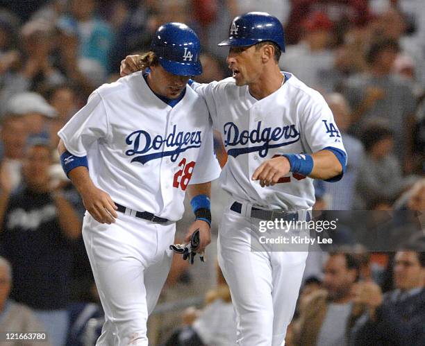 Andy LaRoche of the Los Angles Dodgers is congratulated by Luis Gonzalez after they scored on a bases-loaded triple by Rafael Furcal in the third...