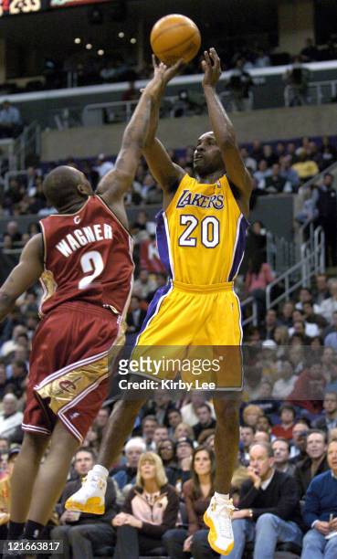 Gary Payton of the Los Angeles Lakers shoots over Dajuan Walker during the game between the Cleveland Cavaliers and the Los Angeles Lakers at the...