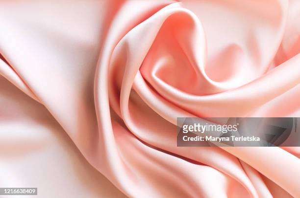 background from satin fabric of peach color. - materiale tessile foto e immagini stock